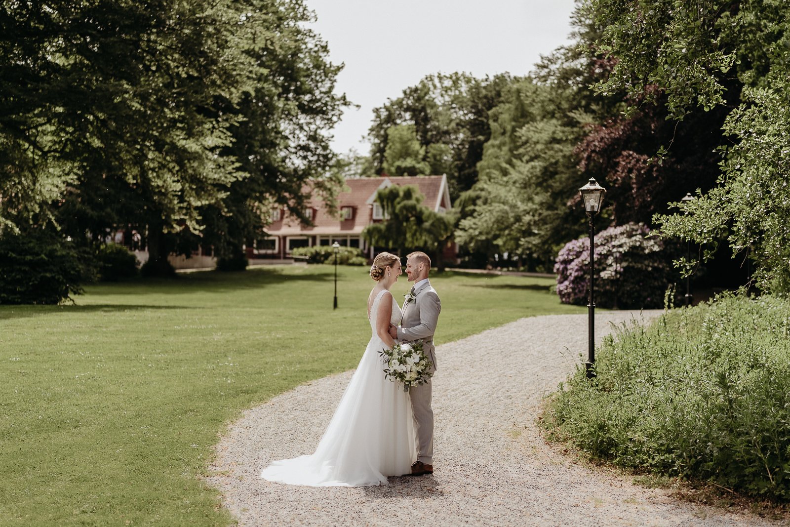 Par står tillsammans i ett blommande rapsfält vid Ringsjön i Skåne under bröllopsfotografering med mjukt kvällsljus